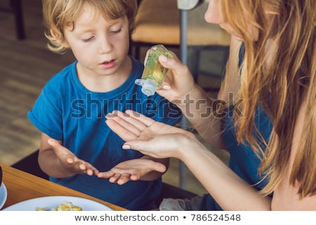 Stock photo: Mother And Son Using Wash Hand Sanitizer Gel In The Cafe