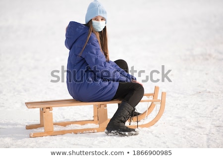 Stock photo: Teenage Girl Riding On Sledge In Snowy Landscape