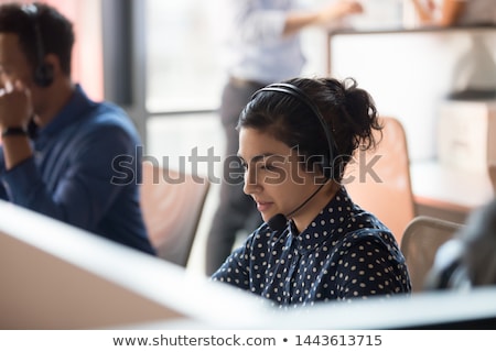 Foto stock: Business Executives With Headsets Using Computers At Desk