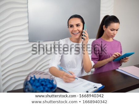 Zdjęcia stock: Young Administrator Of Salon Speaking On Phone