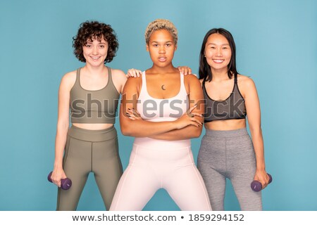 Stock photo: Woman Standing With Dumbbells And Looking At Camera