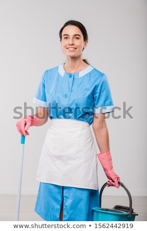 Foto stock: Happy Young Hotel Staff In Uniform And Rubber Gloves Holding Bucket And Mop