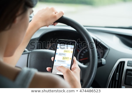 Foto d'archivio: Woman Sitting Inside Car Typing Text Message On Cellphone