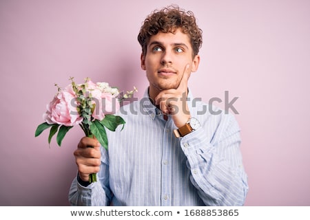 Foto stock: Portrait Of A Pensive Confused Young Man With Curly Hair