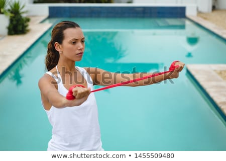 Zdjęcia stock: Front View Of Beautiful Young African American Woman Exercising With Resistance Band In The Backyard