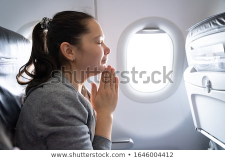 Сток-фото: Young Woman Praying In Airplane