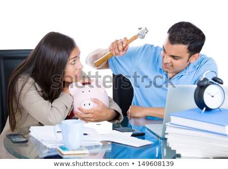 Stok fotoğraf: Man Trying To Break Into A Piggy Bank With A Hammer