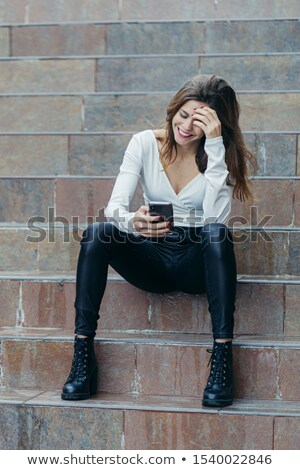 Foto stock: Brunette Woman Sitting On Stone