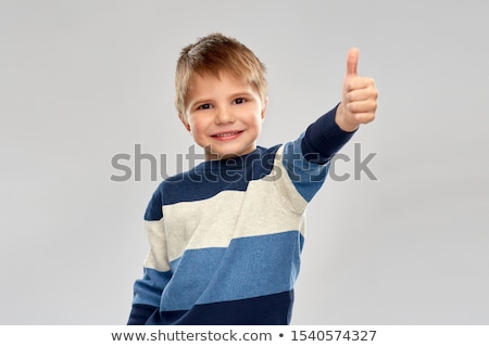 ストックフォト: Smiling Boy In Striped Pullover Showing Thumbs Up