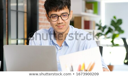 Сток-фото: Young Asian Man Is Serious And Focus When Working On A Laptop On The Table Indonesian Man Wearing B