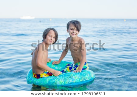 Zdjęcia stock: Brothers In A Swim Ring Have Fun In The Ocean