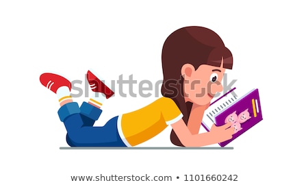 Foto stock: Side View Of Caucasian Schoolgirl Lying On Floor And Reading A Book In Library At Elementary School