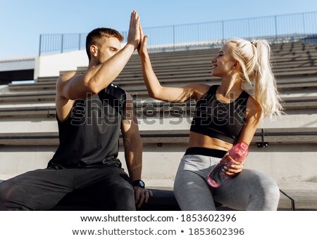Сток-фото: Woman And Man At Break From Running Giving Each Other A High Fiv