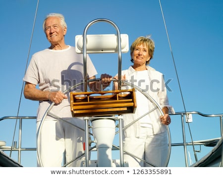 Foto stock: Mature Couple At Wheel Of Yacht Smiling