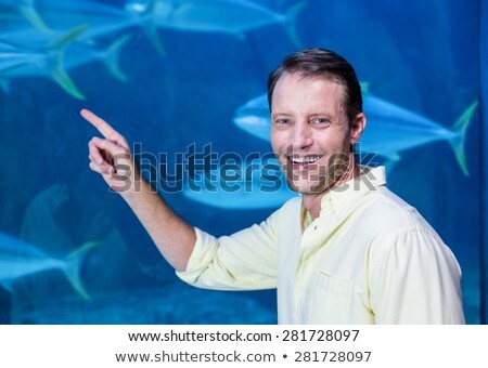 [[stock_photo]]: Man Looks At The Fish In The Aquarium