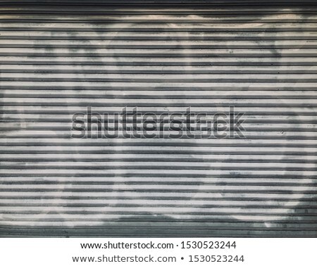 Stockfoto: Old Grungy Industrial Garage Door With Graffitis