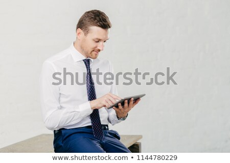 Stockfoto: Horizontal Shot Of Successful Young Businessman Updates Profile On Business Webblog Uses Application