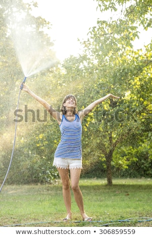 Foto d'archivio: Woman Watering The Garden And Herself