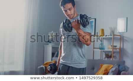 Foto stock: Young Man Exercising Biceps In A Gym