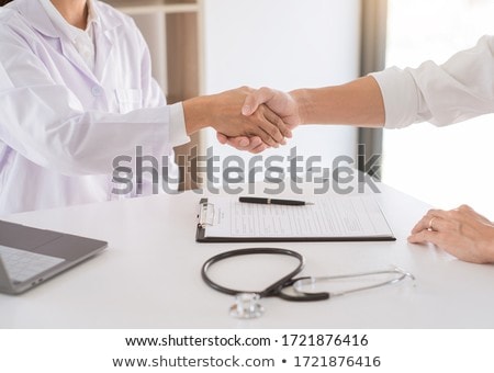 Foto stock: Attractive Doctor And Patient Shaking Hands For Encouragement An