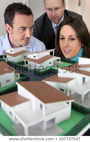 Stock fotó: Architect Showing Scale Model Of House To Buyers