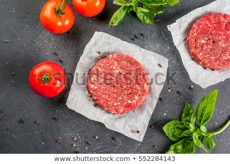 Stock fotó: Fresh Raw Minced Pepper Beef Burger On Stone Chopping Board With Buns Onion And Tomatoes On Black Ba