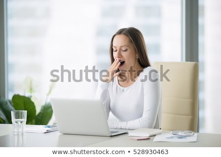 商業照片: Stressed Businesswoman Yawning At Desk