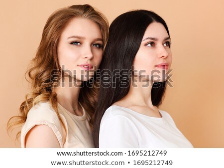 Сток-фото: Two Beautiful Multicultural Young Women Over Beige Background