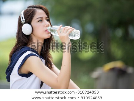 Stok fotoğraf: Pretty Young Woman Drinking Water During Exercise