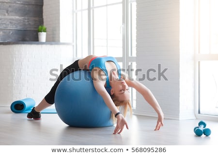 Stok fotoğraf: Young Woman On Pilates Ball In The Gym