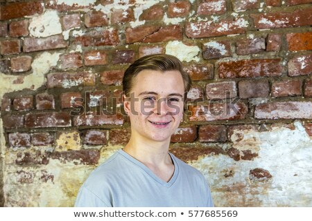 Foto stock: Cute Teenage Boy In Front Of Grungy Brick Wall