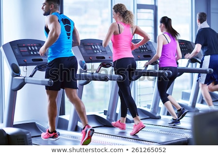 Foto stock: Young People Running On Treadmills In Modern Gym