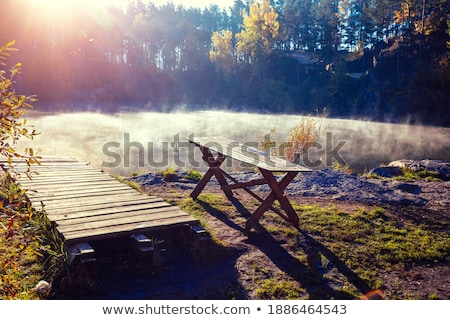 Stock photo: Landscape Of Lake In Mist With Sun Glow At Sunrise With Wooden P