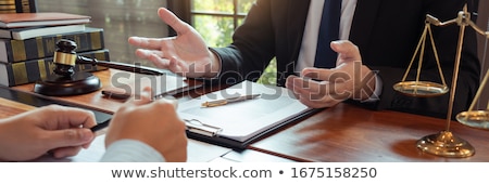 [[stock_photo]]: Lawyer Working With Client Discussing Contract Papers With Brass