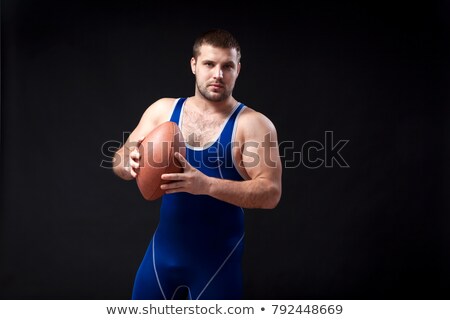 Stok fotoğraf: Portrait Of A Young Man Holding The Ball Tightly Against White