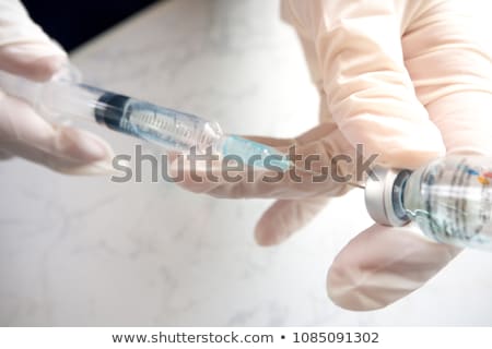 Foto d'archivio: Hand Holding A Syringe And Vial