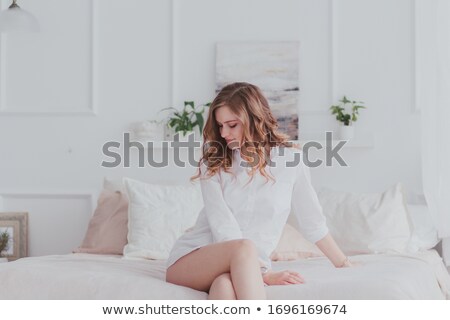 Foto stock: Alluring Attractive Young Woman Sitting On Bed In Bedroom