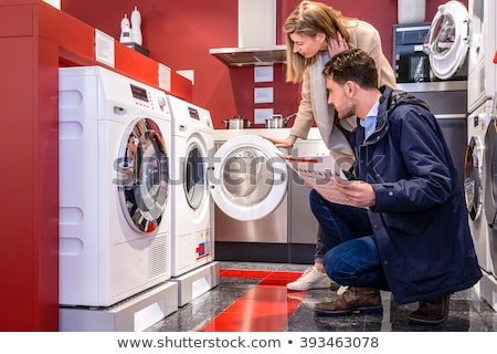 [[stock_photo]]: Couple Choosing Washing Machine At Hypermarket