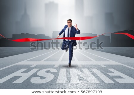 [[stock_photo]]: Businessman In Suit Crossing Red Finish Line Ribbon