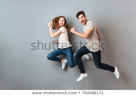 Stockfoto: Full Length Portrait Of A Cheerful Young Couple