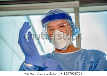 Foto stock: Nurse Or Doctor Putting On Ppe A Medical Face Mask