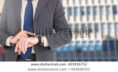 Zdjęcia stock: Businessman Torso Showing His Watch Against A Building