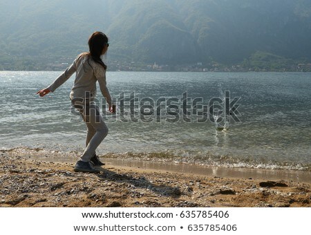 Stok fotoğraf: Little Girl Throwing Stones Into The Sea
