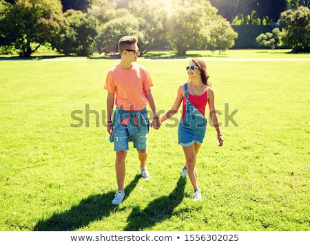 Foto stock: Teenage Boy With Sunglasses Walks Happy On The Meadow