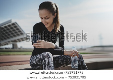 Foto stock: Sporty Woman Texting On Smartphone After Urban Workout