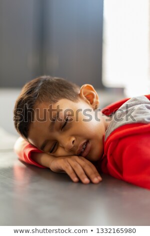 ストックフォト: Close Up Of Cute Mixed Race Schoolboy Sleeping At Desk In A Classroom At Elementary School