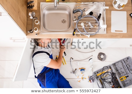 Foto d'archivio: Male Plumber In Overall Fixing Sink Pipe