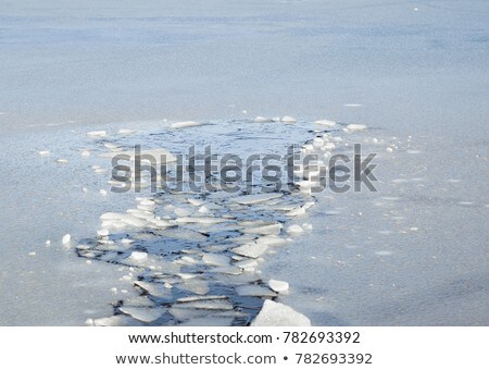 Foto stock: Cracks And Hole In Ice On Pond