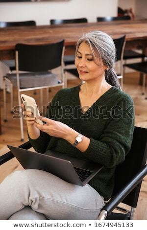 Foto d'archivio: Businesswoman Using Smartphone In Office