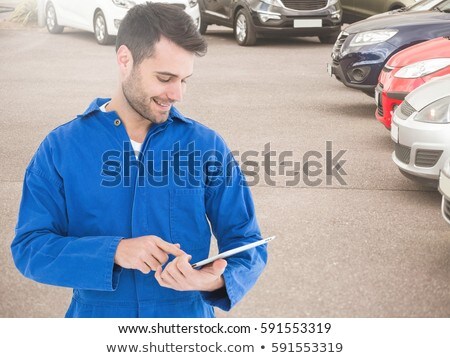 [[stock_photo]]: Smiling Mechanic Using Digital Tablet In Parking Area